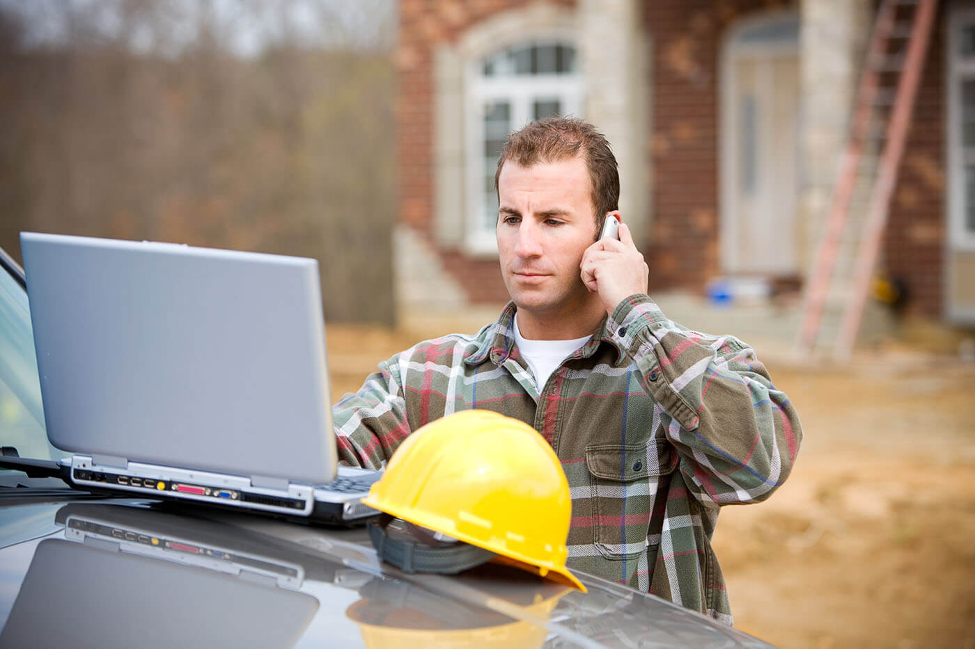 A contractor checking their email while calling a client about an assigned repair from TheQwikFix